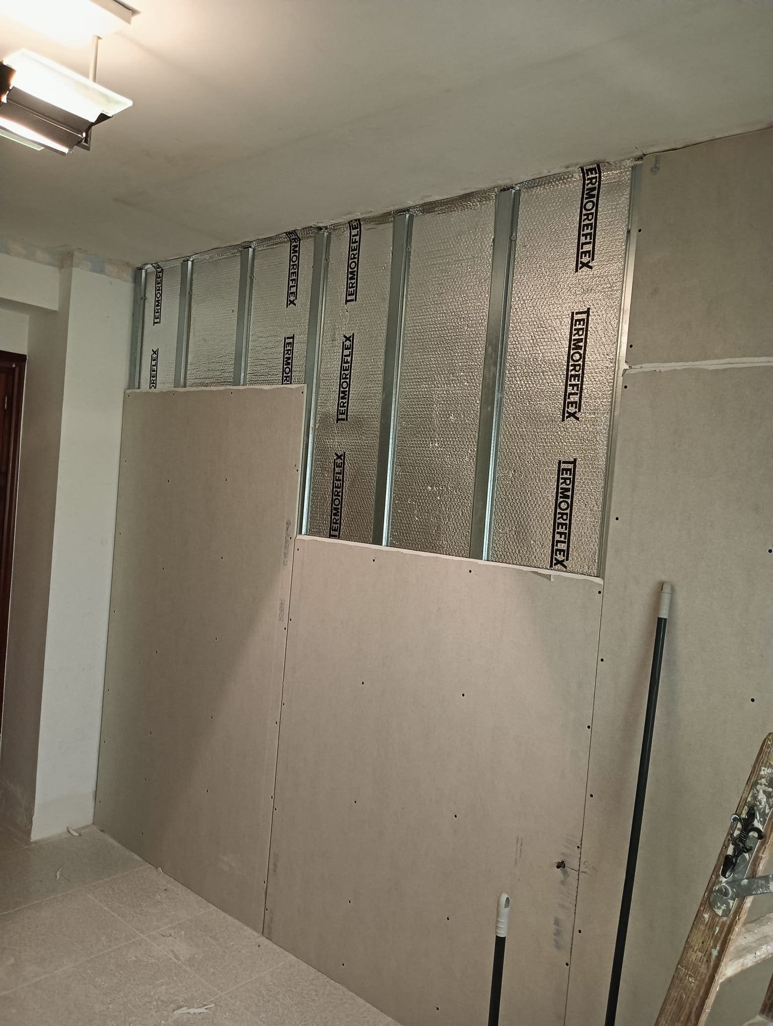 Colocación de placas de yeso laminado sobre un trasdosado con aislamiento