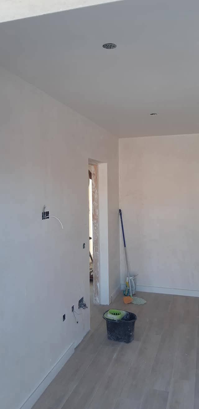 Habitación con paredes alisadas y pintura blanca uniforme terminada
