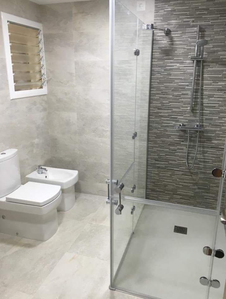 Baño reformado con distribución compacta, inodoro y ducha con mampara