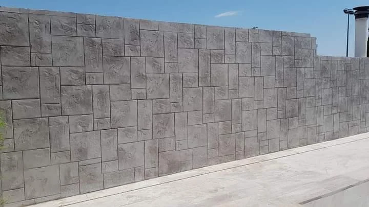 Revestimiento vertical decorativo con acabado de hormigón impreso efecto piedra, diseñado para dar textura y carácter al muro exterior con un resultado uniforme y resistente.